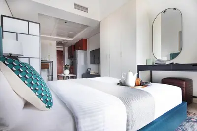 a bedroom with a white bed and a mirror at Frank Porter - Lake View Tower in Dubai