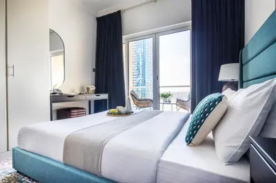 a bedroom with a large bed with a large window at Frank Porter - Lake View Tower in Dubai
