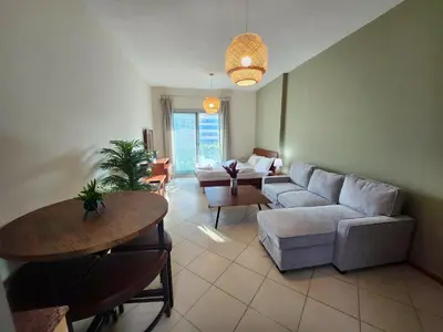 a living room with a couch and a table at Diamond Marina inn, Offers Spacious Apartment 5 min Walk To JBR Beach And METRO in Dubai
