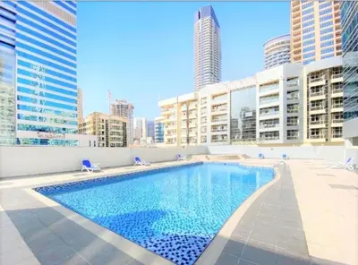 a swimming pool on the roof of a building with tall buildings at Diamond Marina inn, Offers Spacious Apartment 5 min Walk To JBR Beach And METRO in Dubai