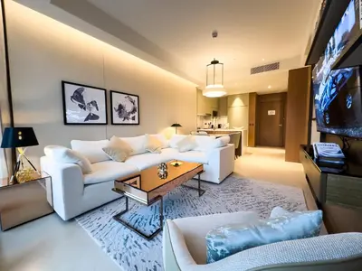 a living room with a white couch and a tv at The Address Residences Dubai Opera, Full Burj Khalifa View, Luxurious 2BR in Dubai