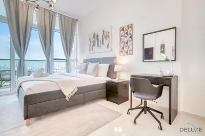a bedroom with a bed and a desk and a chair at Appealing Studio at Carson C DAMAC Hills Dubailand by Deluxe Holiday Homes in Dubai