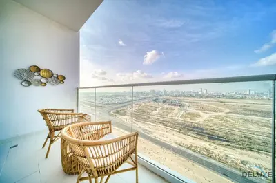 a balcony with chairs and a view of the city at Appealing Studio at Carson C DAMAC Hills Dubailand by Deluxe Holiday Homes in Dubai