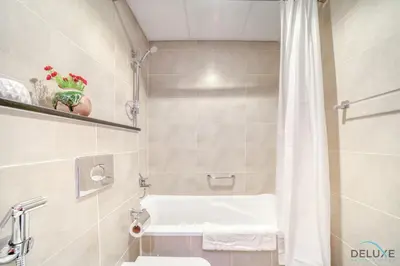 a bathroom with a white tub and a shower at Appealing Studio at Carson C DAMAC Hills Dubailand by Deluxe Holiday Homes in Dubai