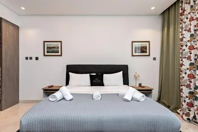 a bedroom with a large bed with two tables at Luxury 1BR Apartment with Burj Khalifa View at Sterling in Dubai