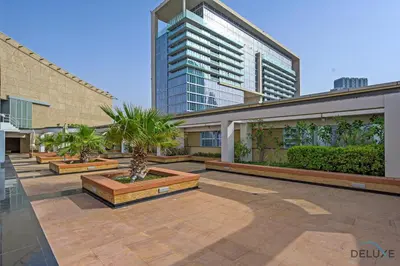 a courtyard with palm trees and a tall building at Limited Time Offer Stylish 1BR near to Metro by Deluxe Holiday Homes in Dubai