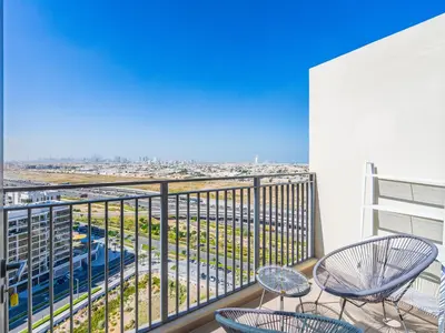 a balcony with chairs and a view of a city at Modern 1BR in Park Heights 2, Dubai Hills in Dubai