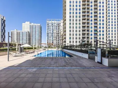 a swimming pool in the middle of a city with tall buildings at Modern 1BR in Park Heights 2, Dubai Hills in Dubai