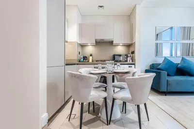 a kitchen and living room with a table and chairs at STAY BY LATINEM Luxury 1BR Holiday Home CVR B1701 near Burj Khalifa in Dubai