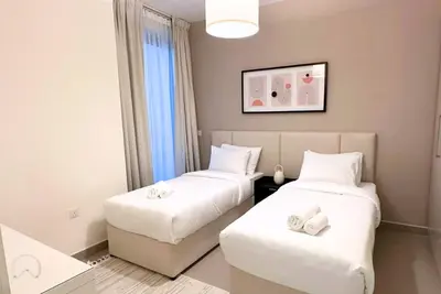 a hotel room with two beds with white sheets at Oraya - Suburban Serenity at Spacious 4BR Villa in Maple 2 in Dubai