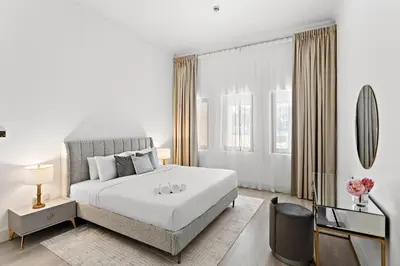 a white bedroom with a large bed and a television at Luxury 4BR Townhouse Palm Jumeirah in Dubai