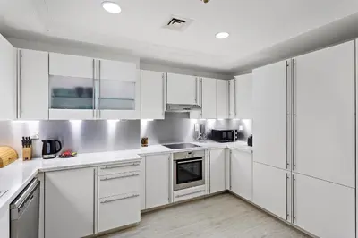 a kitchen with white cabinets and stainless steel appliances at Luxury 4BR Townhouse Palm Jumeirah in Dubai