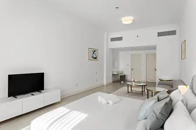a white living room with a white couch and a tv at Luxury 4BR Townhouse Palm Jumeirah in Dubai