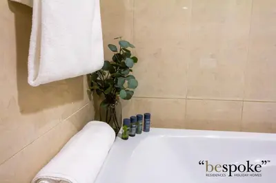 a bathroom with a bath tub with a vase with a plant at Bespoke Holiday Homes - Palm Jumeirah -2 Bedroom Sea View with Beach Access, Balqis in Dubai