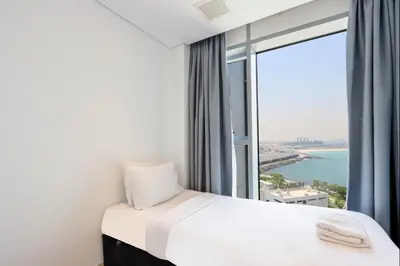 a hotel room with a bed and a large window at Livbnb - Bluewaters 3BR plus Maid's, with Sea Views in Dubai