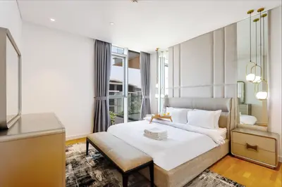 a bedroom with a white bed and a chair at Livbnb - Bluewaters 3BR plus Maid's, with Sea Views in Dubai