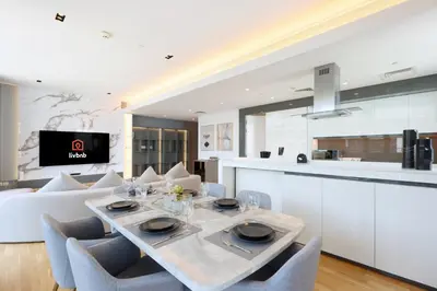 a kitchen and living room with a table and chairs at Livbnb - Bluewaters 3BR plus Maid's, with Sea Views in Dubai