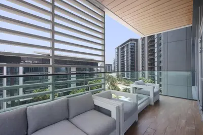 a balcony with a couch and chairs on a building at Livbnb - Bluewaters 3BR plus Maid's, with Sea Views in Dubai