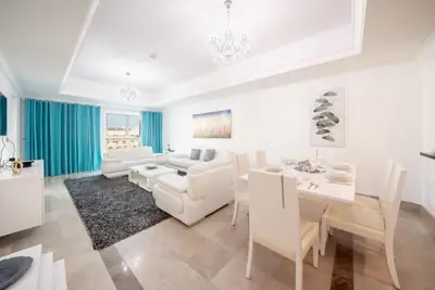 a living room with white furniture and a table at Stylish Urban Retreat 1BR Gem Fairmont Residence - 90AB2 in Dubai
