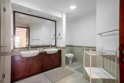 a bathroom with two sinks and a mirror and a toilet at Stylish Urban Retreat 1BR Gem Fairmont Residence - 90AB2 in Dubai