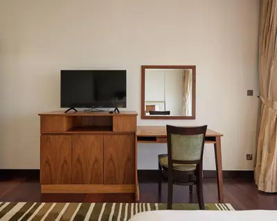 a room with a desk with a television and a chair at Authentic 2 bdr in Anantara Resort Palm Jumeirah in Dubai
