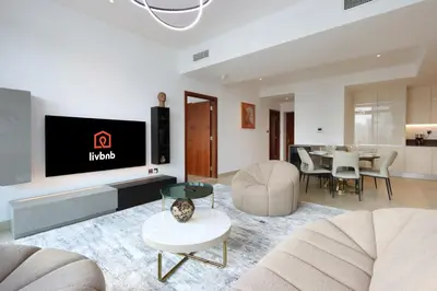 a living room with a tv on a wall at Livbnb Elegant 3BR in Marina Gate Panoramic Marina Views with Private Balcony in Dubai