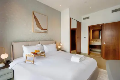 a bedroom with a white bed with a table on it at Livbnb Elegant 3BR in Marina Gate Panoramic Marina Views with Private Balcony in Dubai