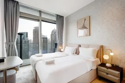 a hotel room with two beds and a large window at Livbnb Elegant 3BR in Marina Gate Panoramic Marina Views with Private Balcony in Dubai