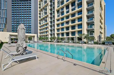 a swimming pool with a chair and an umbrella at Stylish 2BR with Burj Khalifa View at Burj Royale Downtown Dubai by Deluxe Holiday Homes in Dubai