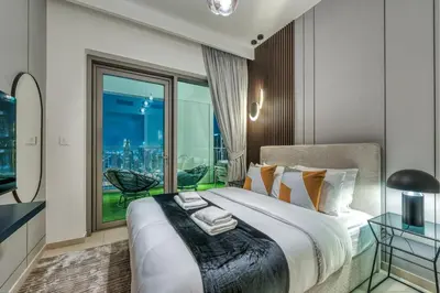 a bedroom with a large bed with a large window at Dubai Mall Connection - Burj Views - Turf Balcony in Dubai