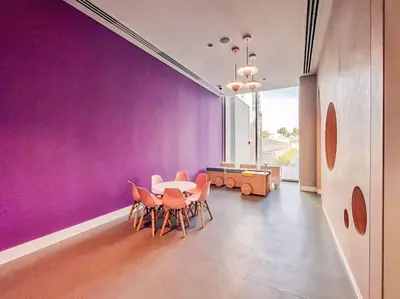 a dining room with purple walls and a table and chairs at Dubai Mall Connection - Burj Views - Turf Balcony in Dubai