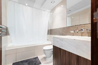 a bathroom with a tub and a toilet and a sink at StoneTree - Spacious 1 BR Apartment in Dubai Marina in Dubai