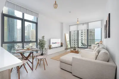 a white living room with a couch and a table at NEW Listing - Czechin - JBR Beach a Few Steps Away in Dubai