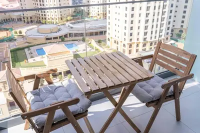 a wooden table and two chairs sitting on a balcony at NEW Listing - Czechin - JBR Beach a Few Steps Away in Dubai