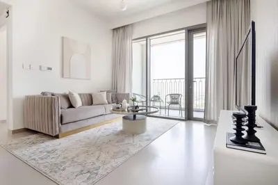 a white living room with a couch and a table at Frank Porter - Downtown Views II in Dubai