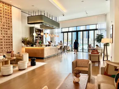 a lobby with a restaurant with people sitting at tables at VIDA Residences Dubai Marina 1BR - Seaview, JBR, Dubai Eye in Dubai