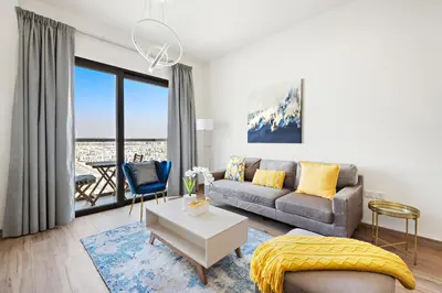 a living room with a couch and a table at StoneTree - Cozy 1 BR Apartment in Al Furjan in Dubai