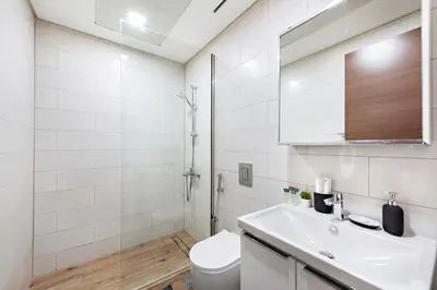 a white bathroom with a sink and a toilet at StoneTree - Cozy 1 BR Apartment in Al Furjan in Dubai