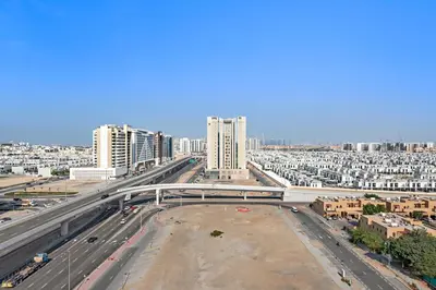 a highway in a city with tall buildings at StoneTree - Cozy 1 BR Apartment in Al Furjan in Dubai