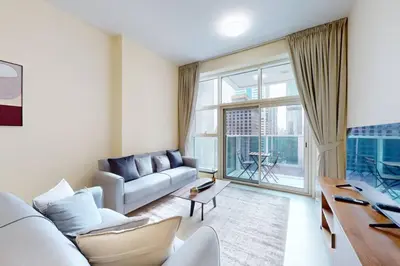 a living room with a couch and a large window at Marina Arcade - Neat Two Bedroom in Dubai