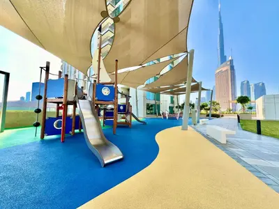 a playground with a slide and swings at Downtown Views 1BR - Dubai Mall, Fountain & Burj Khalifa access in Dubai