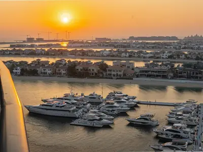 a group of boats docked in a harbor at sunset at Daniels Sea View 2BR in Oceana The Palm Jumeirah in Dubai