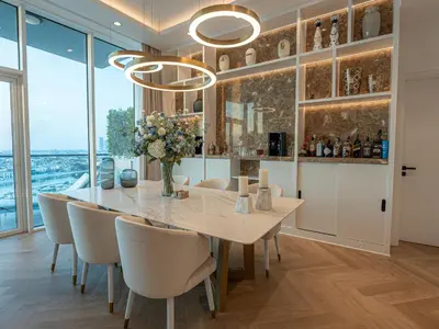 a dining room with a table and chairs and windows at Daniels Sea View 2BR in Oceana The Palm Jumeirah in Dubai