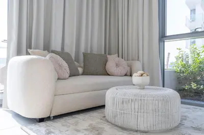a living room with a white couch and a table at Crystal water lagoon living in District One in Dubai