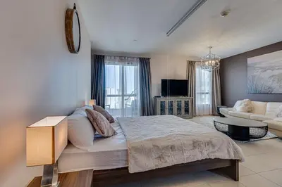 a bedroom with a bed and a living room at Studio sea view in Dubai