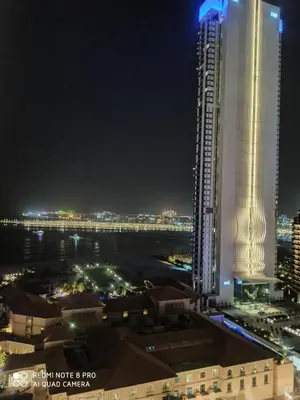 a view of a city at night with a tall building at Studio sea view in Dubai
