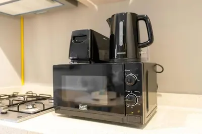 a microwave with a coffee pot on top of it at The View 1 Bedroom in Dubai
