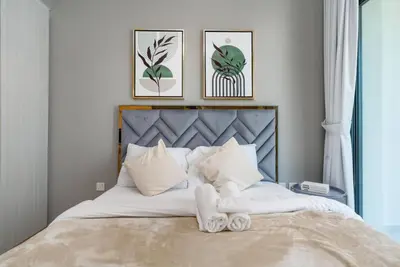 a bedroom with a bed with two towels on it at The View 1 Bedroom in Dubai