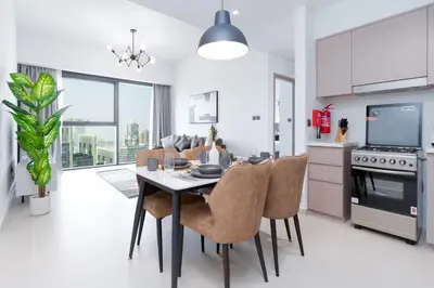 a kitchen and dining room with a table and chairs at White Sage - Act One Tower in Dubai