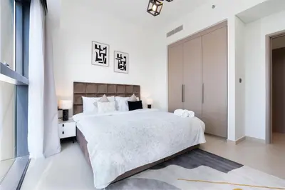 a bedroom with a large bed with white walls at White Sage - Act One Tower in Dubai